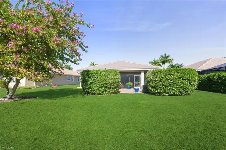 Rear view of house featuring a sunroom and a yard