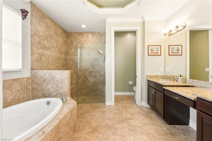 Full bath with vanity, a garden tub, a walk in shower, ornamental molding, and recessed lighting