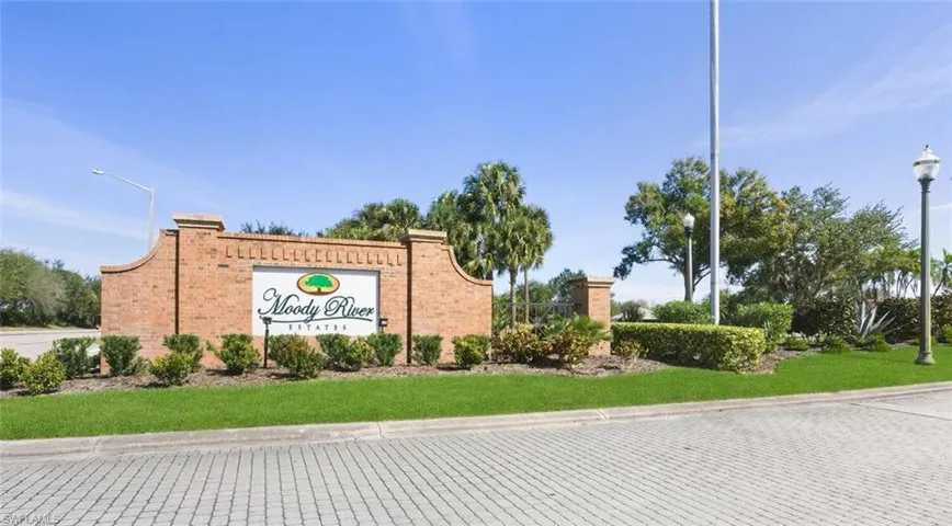 Community / neighborhood sign featuring a lawn
