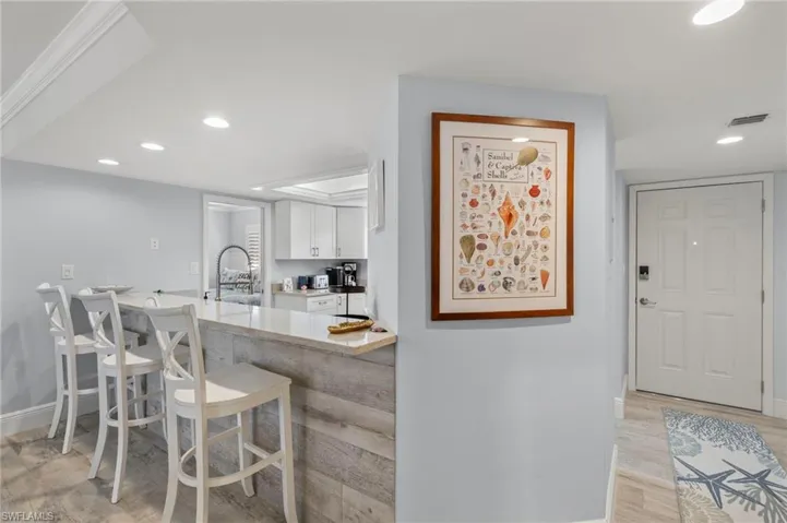 Kitchen with white cabinets, a breakfast bar area, light wood-type flooring, sink, and kitchen peninsula