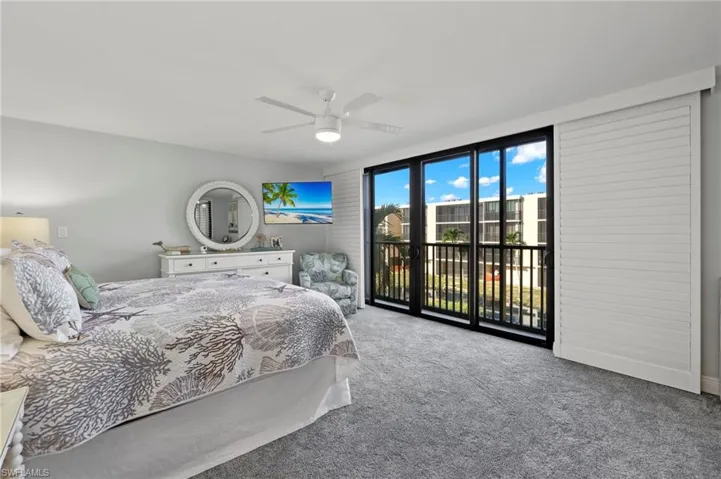 Carpeted bedroom featuring ceiling fan and access to exterior