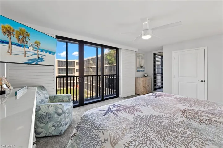 Carpeted bedroom featuring ceiling fan and access to exterior