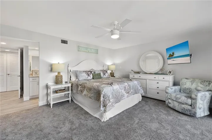 Bedroom with ceiling fan, wood-type flooring, and ensuite bathroom
