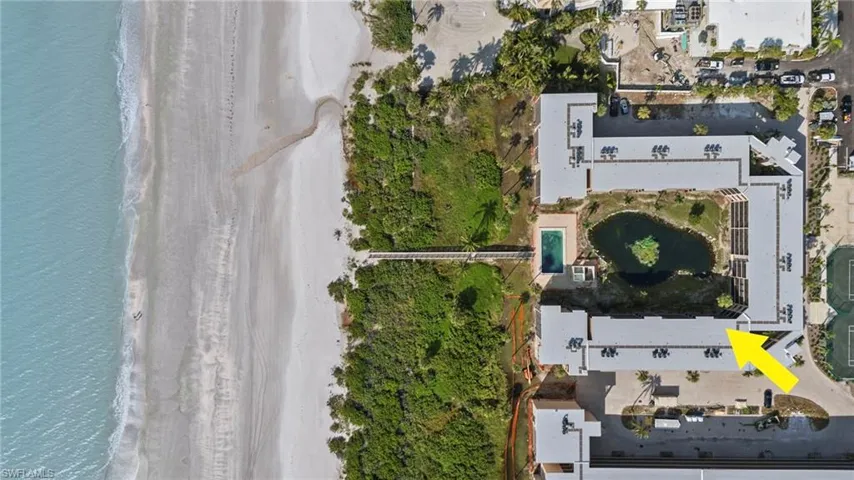 Birds eye view of property with a water view and a view of the beach