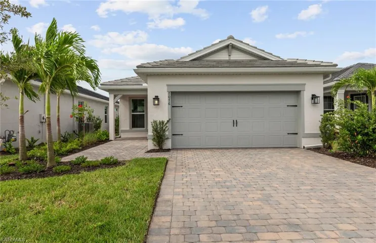 View of front of home with a front yard and a garage