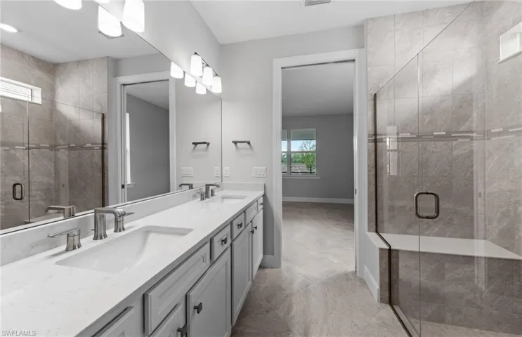 Bathroom with tile patterned floors, an enclosed shower, and vanity