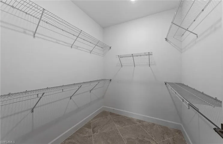 Walk in closet with tile patterned floors