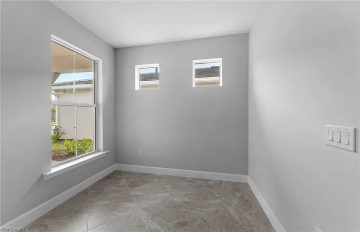 Tiled spare room with a healthy amount of sunlight