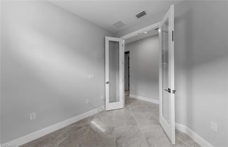 Unfurnished bedroom featuring french doors