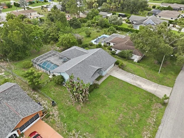 Single-story residence featuring a screened-in swimming pool, a concrete driveway, and a shingle roof