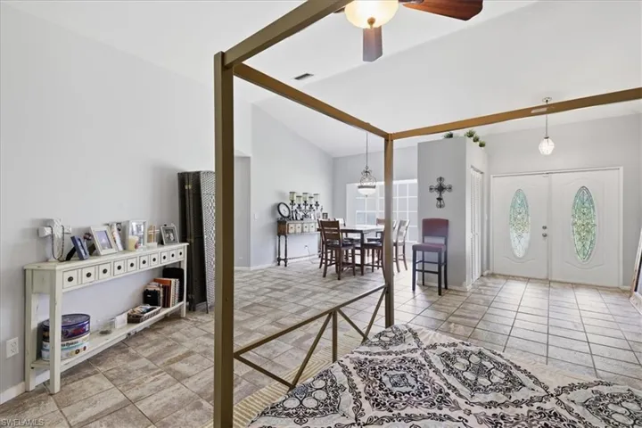 Vaulted ceilings accent an open living space featuring tile flooring throughout