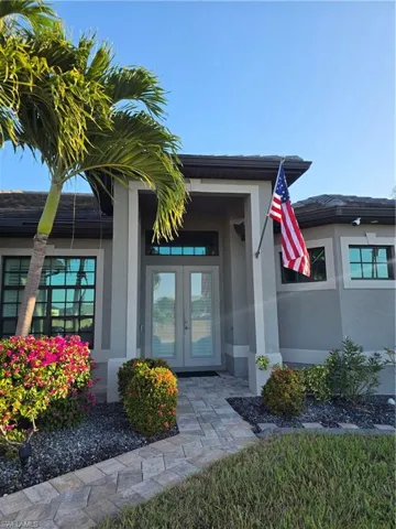 View of exterior entry with stucco siding and french doors