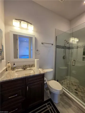 Bathroom / Pool Bath with a stall shower, vanity, and a textured wall