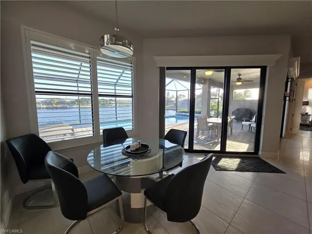 Dining room featuring a water view, tile patterned flooring, and a sunroom