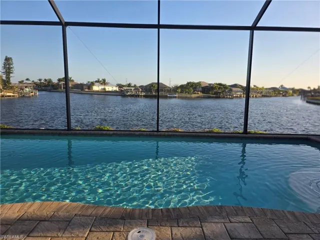 Swimming pool featuring a lanai, a sunroom, and a water view