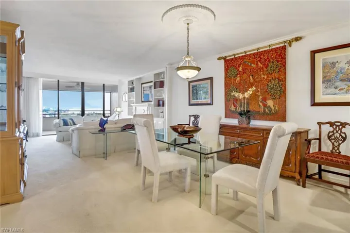 Carpeted dining space featuring a wall of windows and ornamental molding