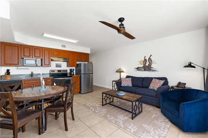 Tiled living room featuring ceiling fan and sink