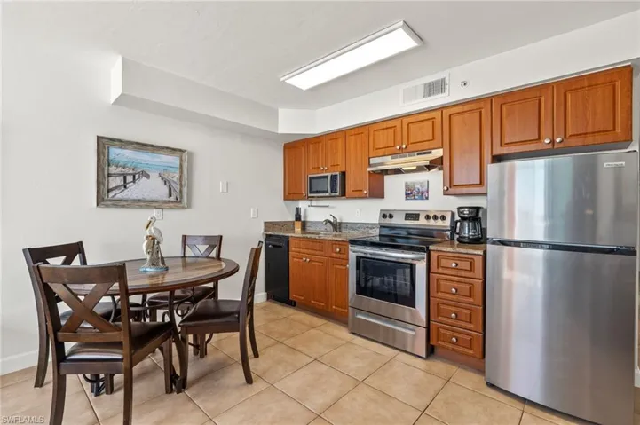 Kitchen featuring light stone counters, light tile patterned floors, stainless steel appliances, and sink
