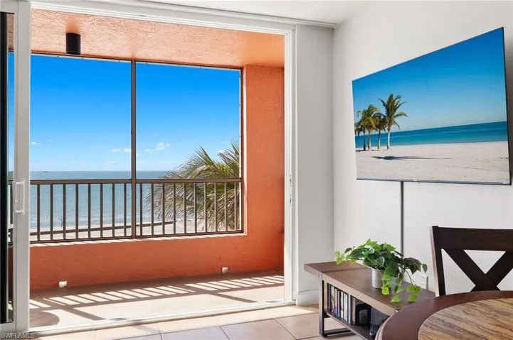 Sunroom with a water view, a wealth of natural light, and a beach view