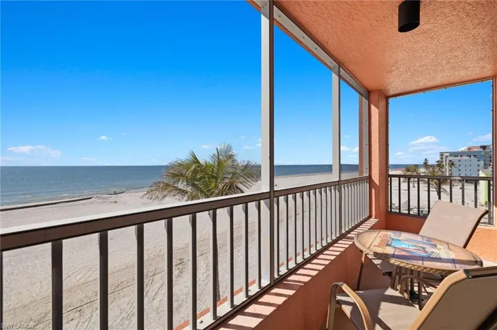 Sunroom / solarium featuring a beach view and a water view