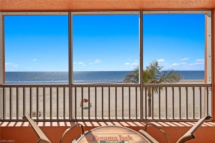 Unfurnished sunroom with a view of the beach and a water view