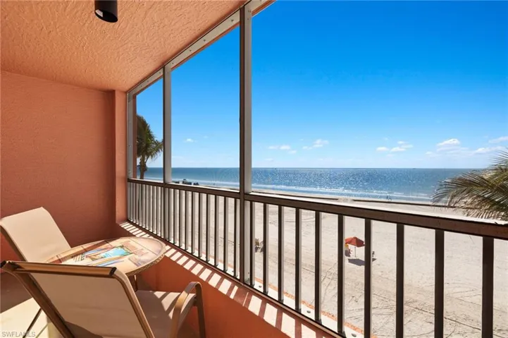 Unfurnished sunroom featuring a water view and a view of the beach