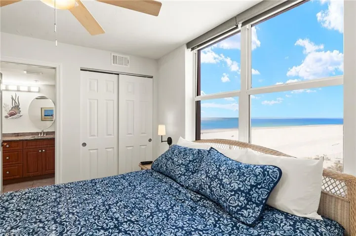 Bedroom featuring sink, a closet, ceiling fan, and a water view