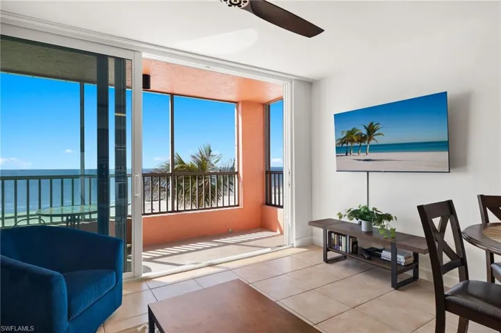 Tiled living room with a water view and ceiling fan