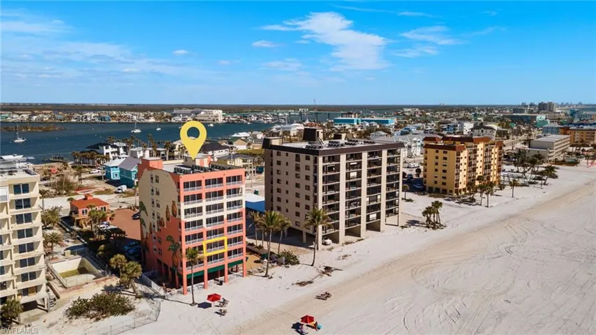 Birds eye view of property featuring a water view and a view of the beach