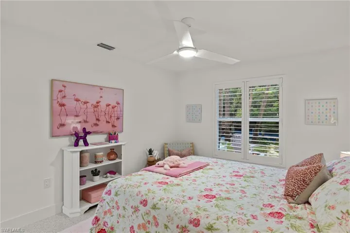 Carpeted bedroom featuring ceiling fan