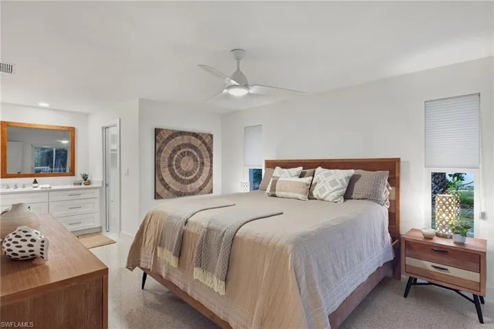 Bedroom featuring ceiling fan, light colored carpet, and sink