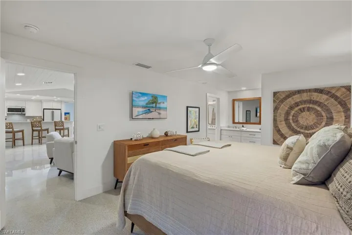 Bedroom with lofted ceiling, white refrigerator, and ceiling fan