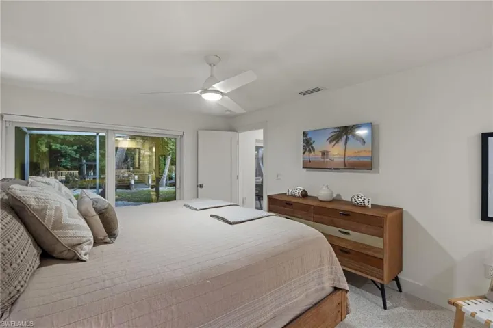 Carpeted bedroom featuring ceiling fan and access to exterior