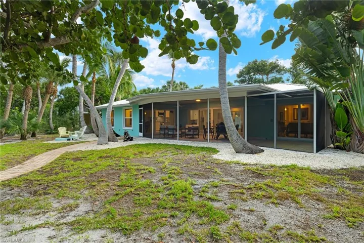 Rear view of property with a sunroom and a patio area