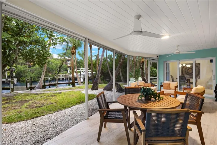 Sunroom featuring ceiling fan, a water view, and wooden ceiling