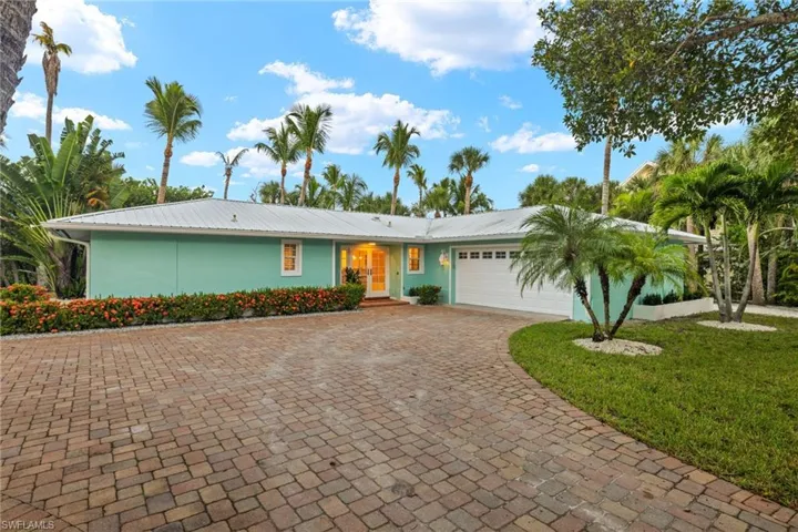 Single story home with a garage and a front lawn