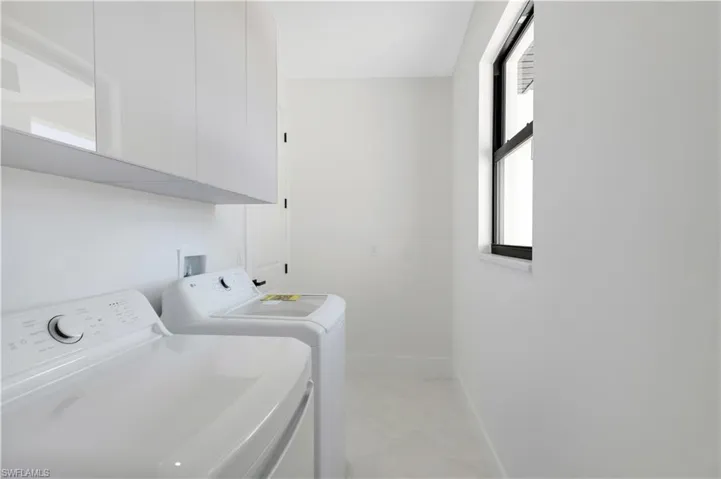 Laundry room with cabinet space and washer and clothes dryer