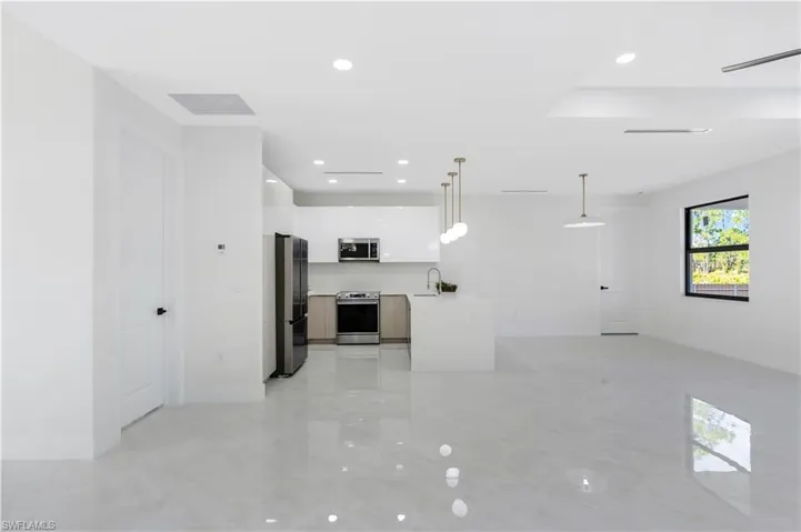 Unfurnished living room featuring recessed lighting and a sink