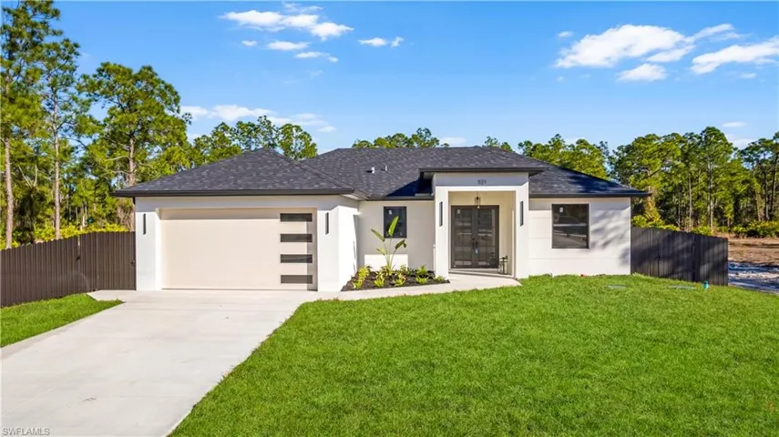 View of front of home featuring an attached garage, driveway, stucco siding, and a shingled roof