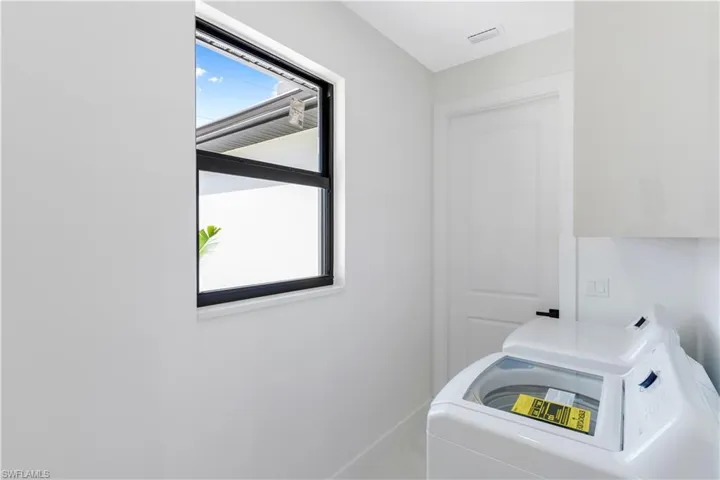 Laundry room with washing machine and dryer and baseboards