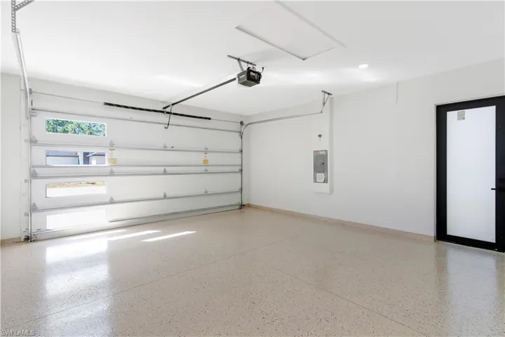 Garage with modern epoxy coating, electric panel and a garage door opener