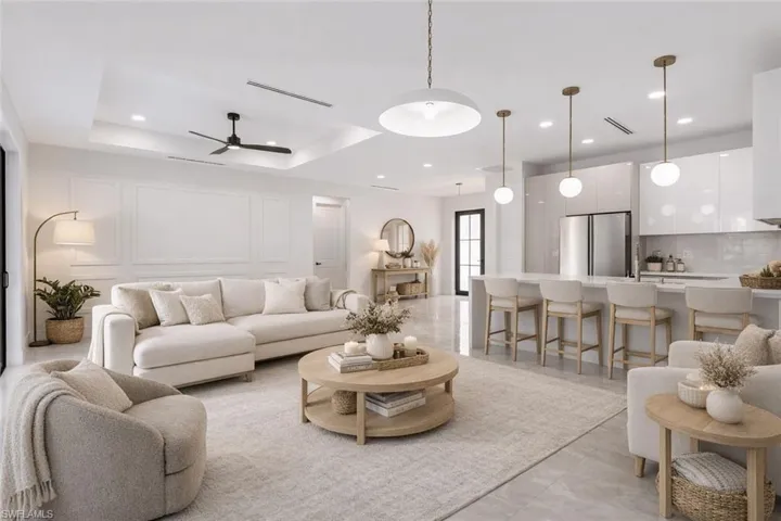 Virtually Staged Living room with a decorative wall, a ceiling fan, a raised ceiling, recessed lighting, and light tile patterned floors