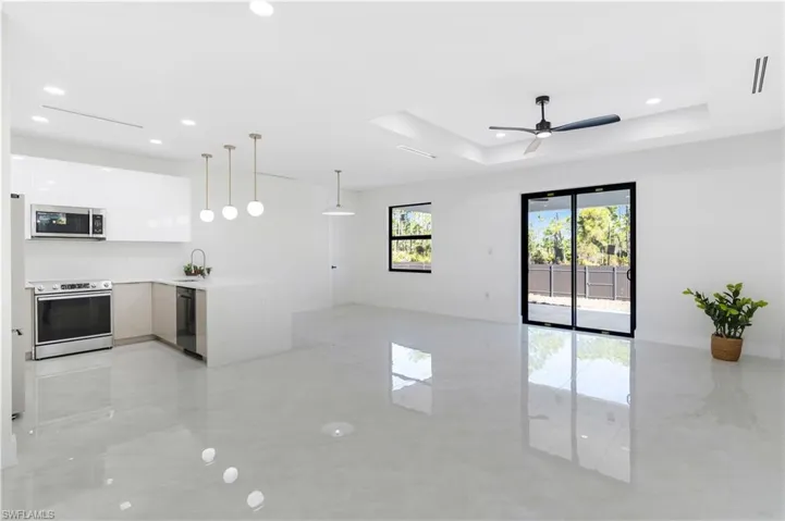 Kitchen featuring open floor plan, modern cabinets, stainless steel appliances, pendant lighting, and a peninsula