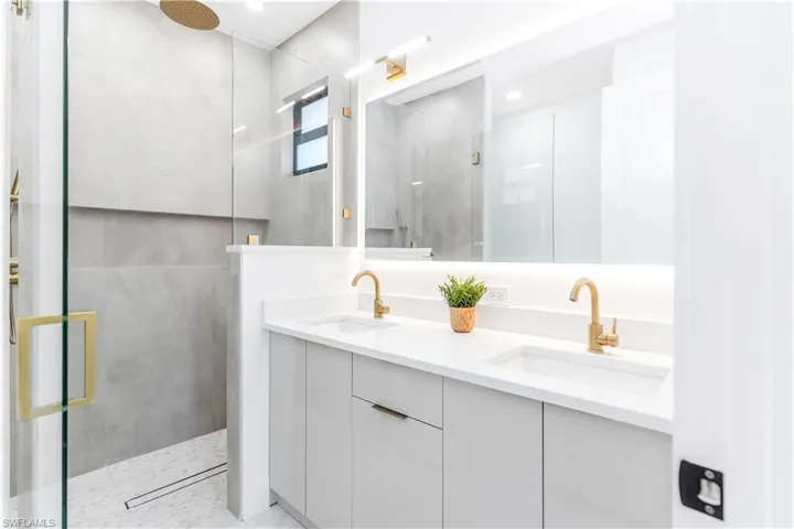 Bathroom with double vanity and a stall shower