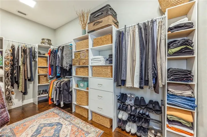 Spacious closet with dark wood-type flooring