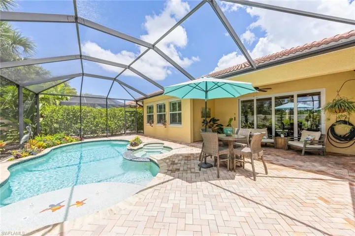 View of swimming pool featuring a patio and glass enclosure