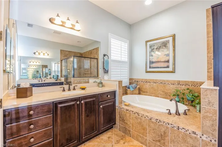 Bathroom with independent shower and bath, vanity, and tile patterned floors