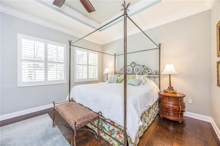 Bedroom with ornamental molding, hardwood / wood-style floors, and ceiling fan