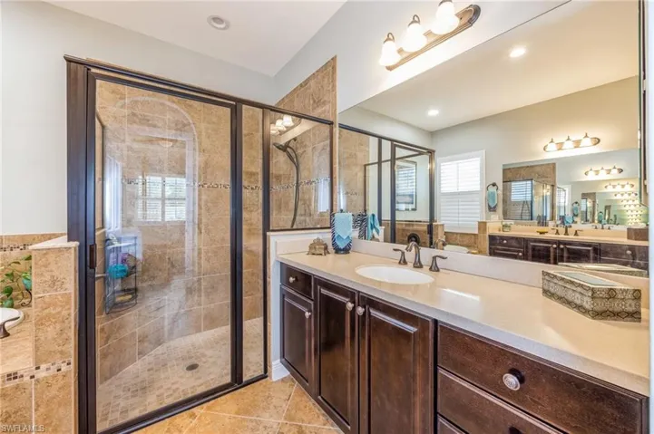 Bathroom with vanity, tile patterned flooring, and walk in shower