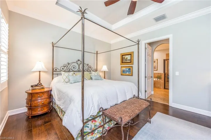 Bedroom with multiple windows, ceiling fan, and hardwood / wood-style floors